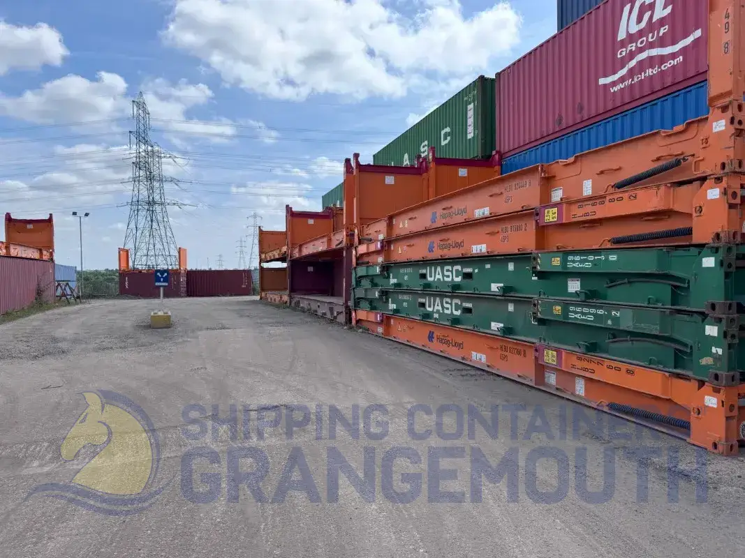 A shipping yard filled with colorful containers and power lines under a blue sky with clouds.